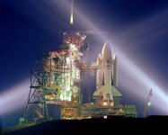 Explanation: On April 12, 1981, twenty years ago today, the Space Shuttle Columbia became the first shuttle to orbit the Earth. In this gorgeous time exposure, flood lights play on the Columbia and service structures (left) as it rests atop Complex 39's Pad A at Kennedy Space Center in preparation for first launch. Flown by Commander John W. Young and Pilot Robert L. Crippen, Columbia spent 2 days aloft on its check-out mission, STS-1, which ended in a smooth landing, airplane-style, at Edwards Air Force Base in California. Ferried back to Kennedy by a modified Boeing 747, Columbia was launched again seven months later on STS-2, becoming the first piloted reuseable orbiter. The oldest operating shuttle, Columbia's 1981 debut was followed by shuttles Challenger in 1982 (destroyed in 1986), Discovery in 1983, Atlantis in 1985, and Challenger's replacement Endeavour in 1991. This shuttle fleet has now accomplished over 100 orbital missions. Today also marks the 40th anniversary of the first human in space, Yuri Gagarin.